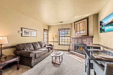 A cozy living room with one sofa, TV, gas burning fireplace, and dining table for two guests.