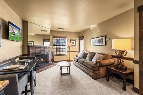 Unwind in your cozy living space where a warm fireplace crackles beside plush seating and modern amenities.
