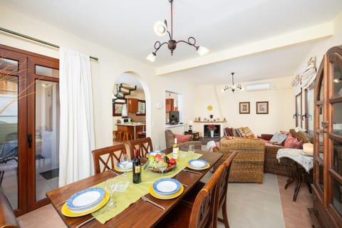 Living room with sofa, dining area, ornamental fireplace, A/C, WiFi internet, and satellite TV