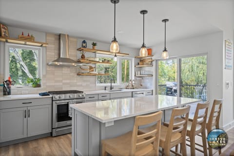 Kitchen with breakfast bar seating, sliding door to balcony.