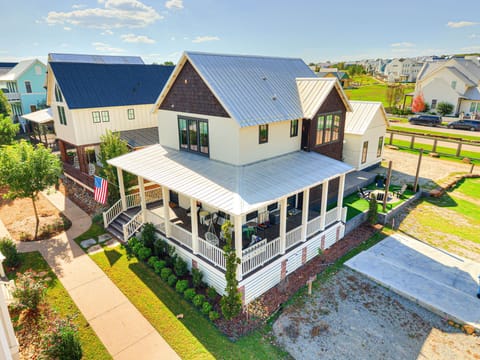 1. Aerial view highlighting Hideaway 56’s corner-lot setting with a full wraparound porch and manicured landscaping — privacy and connection in the heart of Carlton Landing.
