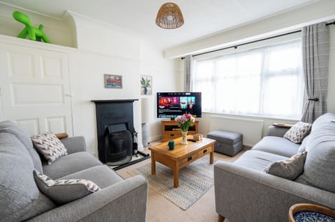 Bright, cosy living room with two plush sofas, Netflix and board games.