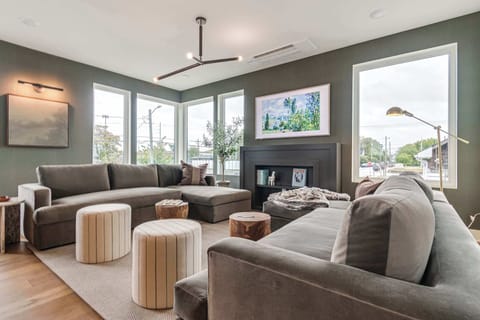 Bright and airy living room with oversized sectional seating, large windows, and smart TV — perfect for relaxing together.