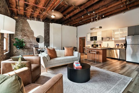 Your Living Room awaits! Stylish space with exposed brick, modern decor, and vibrant lighting for your gatherings!