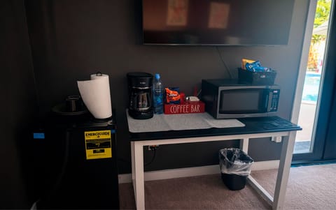 In-room amenities in The Red Room, including a coffee station, microwave, mini fridge, and flat-screen TV.