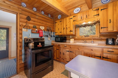 Step into your rustic retreat's fully-equipped kitchen, where warm wood surrounds modern appliances for perfect mountain cooking adventures.