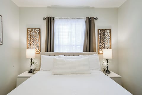 Front House Bedroom with queen sized bed, walk-in closet, hangers, and smart TV