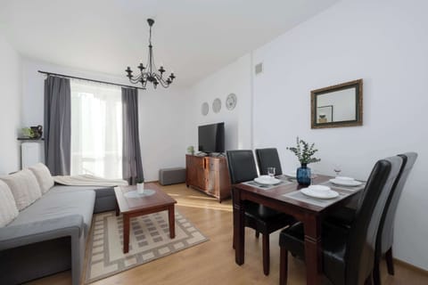 A bright interior with a large window, soft sofa and dining table creates a space perfect for relaxing and enjoying a meal in a cozy setting.