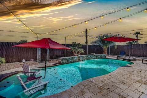 Private pool with lounge seating and evening string lights.