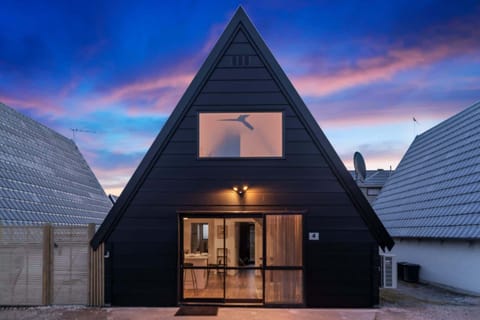 Striking A-frame design glowing under a Queenstown sunset