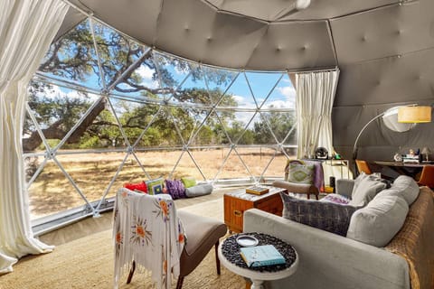 Step inside your geodesic dome retreat featuring modern comfort, cozy seating, and colorful Hill Country style.