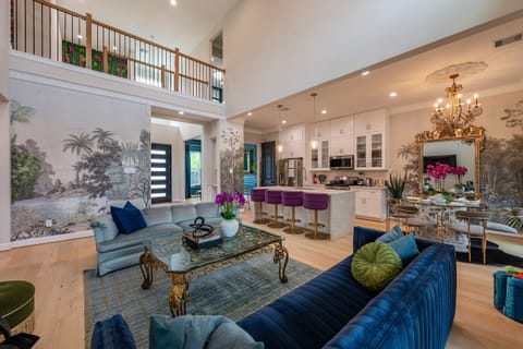 Elegant open-concept living with soaring ceilings and designer wallpaper and style