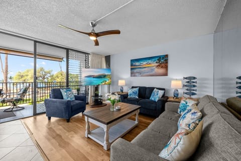Relax in an open-concept living space with Hawaiian-inspired décor, updated flooring, and large sliding doors that blend indoor and outdoor living.