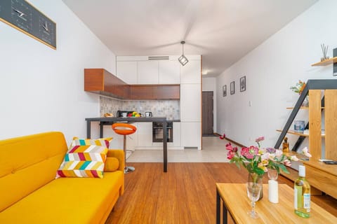Open-Concept Living Room with Bright Sofa, Modern Kitchen and Large Smart-TV | Book Now with RENTUJEMY.COM