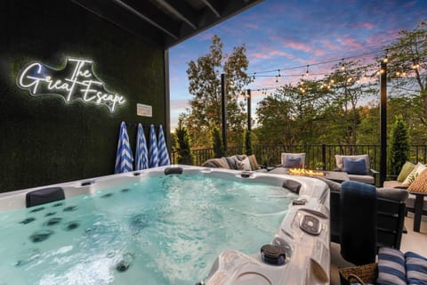 Relax in the outdoor hot tub with a cozy fire pit and scenic tree views at sunset.
