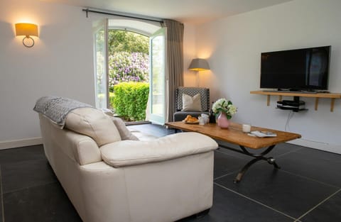 Living area with sofa, TV and doors leading to the patio