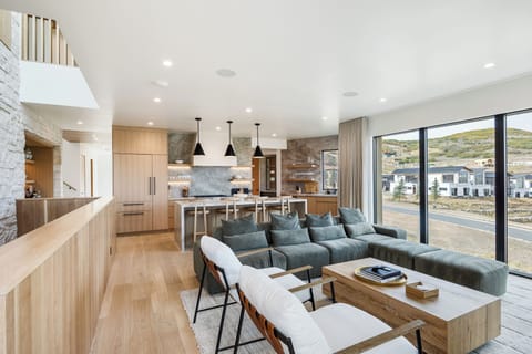 Stunning open-concept great room with a spacious kitchen, large island, and comfortable living area. Floor-to-ceiling windows fill the space with light and showcase breathtaking views—perfect for gathering and entertaining.