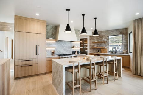 Stunning chef's kitchen with high-end appliances, a spacious island with bar seating, and elegant modern finishes
