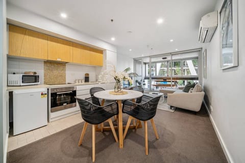 Share slow breakfasts or takeaway dinners around the dining table, with woven chairs and warm finishes adding to the apartment’s relaxed feel.