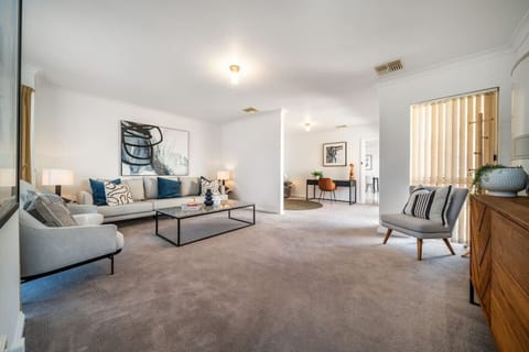 Settle into the main living room where generous seating invites relaxed evenings after a day exploring Adelaide.
