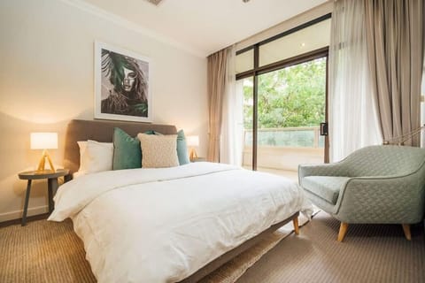 Wake to soft natural light in the primary bedroom, complete with a queen bed and direct balcony access.