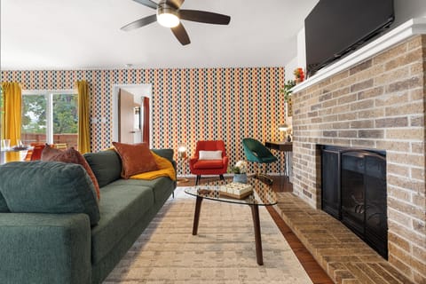 Living room with a cozy fireplace, Roku TV, desk, and record player