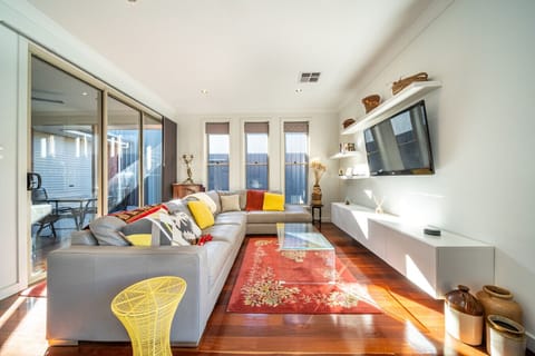 Sink into the spacious L-shaped sofa and unwind with the TV, as soft natural light fills the room.