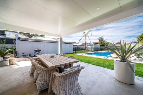 The patio seats eight with a BBQ and views over the pool, ideal for relaxed evenings outdoors.
