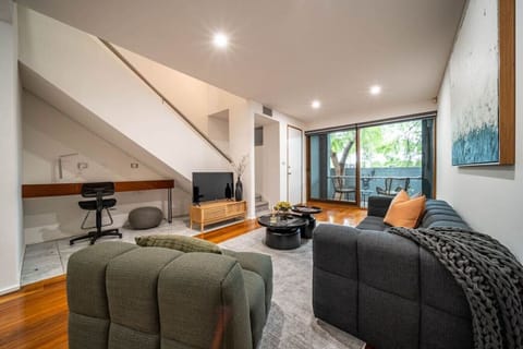 A workspace tucked beneath the stairs offers a practical spot to catch up on emails or plan the day ahead.
