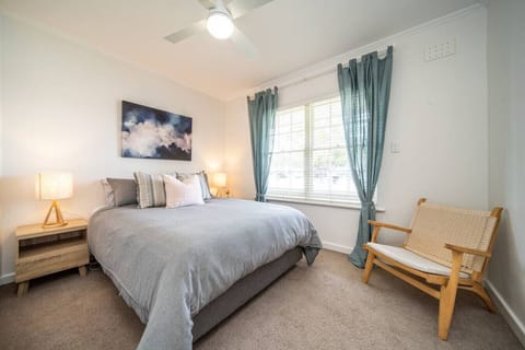 Drift into rest in the primary bedroom with a queen bed, soft natural light and a ceiling fan for added comfort.