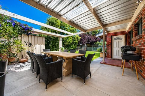 Dine outdoors under the covered patio, where a BBQ and seating area set the scene for laid-back gatherings.