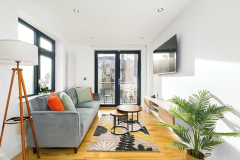 Spacious, sun-filled living area with corner sofa, dining table and balcony — perfect for family meals and movie nights with Netflix