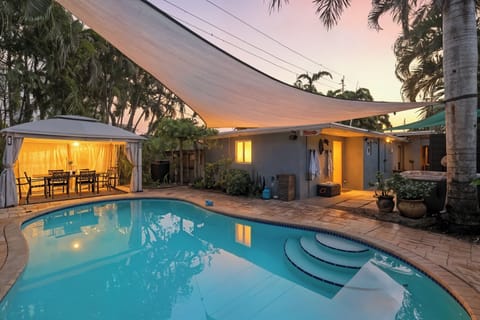 Sunset, palm trees, and the perfect pool. Your backyard oasis featuring pool, dining area under the gazebo and large patio.