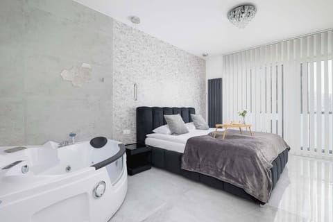 Bright and elegant open-plan studio featuring a chic sitting area and floor-to-ceiling windows.