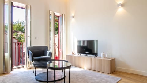 Bright and inviting living room with modern furnishings, creating a welcoming space for relaxation and entertainment. #PortoApartment #LivingRoomGoals #ModernLiving