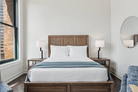 Unwind in crisp linens with sunlit city-facing comfort.
