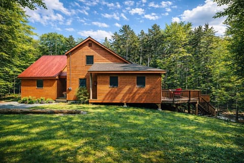 Spacious woodland retreat with a large private deck, expansive lawn, and peaceful forest surroundings perfect for a relaxing getaway.