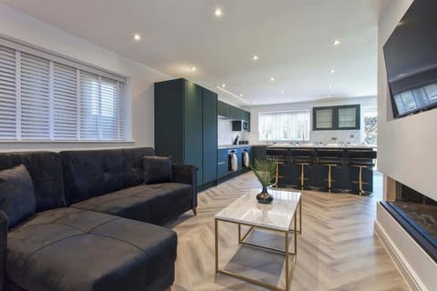 Stylish open-plan living area with a plush corner sofa, modern coffee table, and seamless flow into the kitchen.