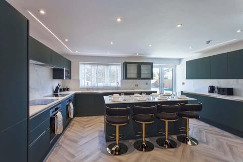 Spacious modern kitchen with breakfast bar seating — perfect for cooking, dining, and socializing.