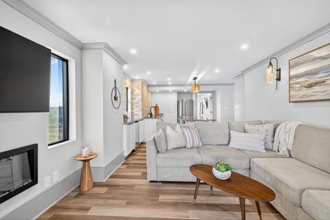 Completely reimagined and remodeled with your comfort in mind. This open concept living room features a custom fireplace, a cozy sectional that faces the 5th floor balcony.