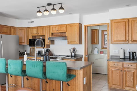 Fully stocked kitchen with counter height barstools, and complimentary coffee, tea, and sugar.