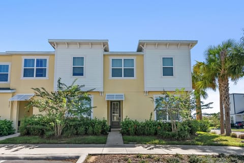 Welcome to your charming getaway with warm yellow siding and large windows that fill the space with natural light. The lush greenery along the pathway offers a delightful entrance to your perfect home away from home in this.