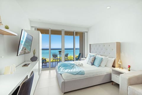 Your serene bedroom sanctuary features a plush bed, private balcony, and stunning ocean views that greet you each morning through floor-to-ceiling windows.