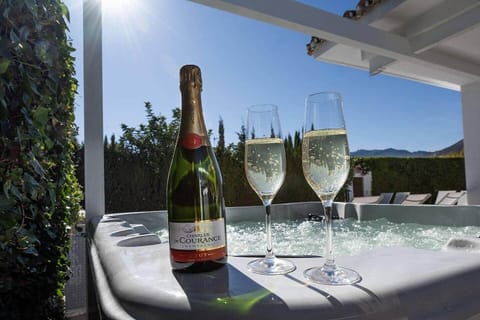 Private hot tub beside the heated pool and spa terrace. A tranquil spot to unwind after a sauna or swim, with soft evening lighting creating the perfect atmosphere for relaxation under the stars.