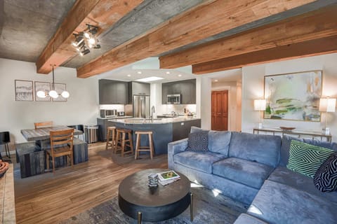 【Living Room】Blue sectional around the fireplace — Mt Crested Butte framed through the window