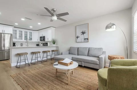 Bright and inviting living space with modern furnishings, cozy sofa, and stylish décor. Open layout flows into a sleek kitchen and breakfast bar—ideal for relaxing, socializing, or unwinding after a day of adventure.