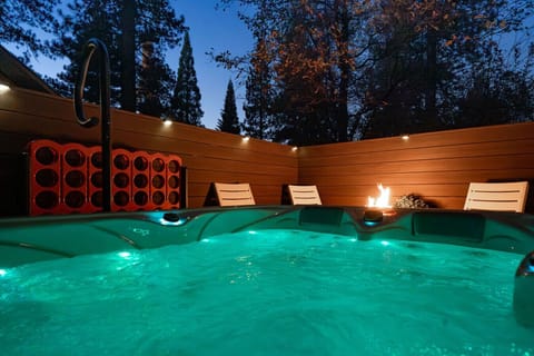 Hot Tub Retreat: Unwind in the shimmering waters beneath a starry sky, with warm flames nearby!