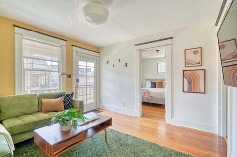 Living room with green sofa and front windows.