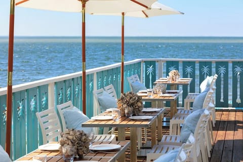 Relax on beachfront loungers facing a glassy, tranquil horizon.