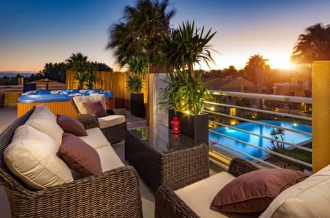Enjoy sunset drinks with rooftop views overlooking the pool and palm trees